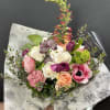 Mixed bouquet of pink, white, and peach flowers wrapped in printed paper