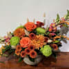 Ceramic bowl filled with an assortment of Fall flowers and foliage.