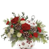 A white ceramic Christmas bauble filled with red and white flowers and