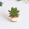 Enamel pin of a potted leafy plant