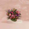 Pink and purple mixed flower arrangement in a glass vase