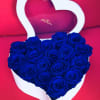 Heart-shaped box of blue roses on a pink background