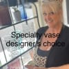 Woman standing by decorative glass vases on a shelf