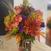 Mixed fall flowers displayed in mason jar.