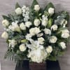 White roses and lilies arranged in a wooden box with greenery.