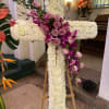 Elegant white cross on aisle. White carnations, lavender roses and Bombay orchid