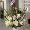 Tall white and lavender floral arrangement in a white vase