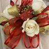 White rose corsage with red and gold ribbon accents