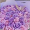 Bouquet of pink and purple roses with a butterfly topper