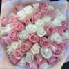 Bouquet of pink and white roses wrapped in pastel paper