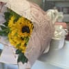 Bouquet of yellow sunflowers wrapped in pink patterned paper