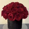 Red roses arranged in a black cylindrical box