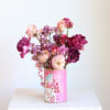 Pink and purple roses in a decorated tin can vase
