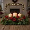 Red roses and candles arranged in a holiday centerpiece