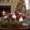 Christmas floral centerpiece with red roses and white poinsettias in a gold box