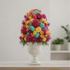 Colorful floral arrangement in a white urn vase with decorative eggs