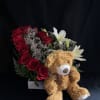Red rose arrangement with white lilies and a teddy bear