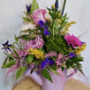 Mixed bouquet in a lavender watering can with pink, purple, and white flowers