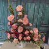 Large pink floral arrangement in a white vase
