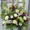 Large white and green floral arrangement in a white vase