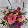Pink gerbera daisies and mixed blooms in a wooden box arrangement