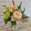 Bouquet of pale peach and white flowers in a white vase
