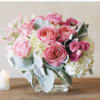 Pink rose bouquet in a clear glass vase with white hydrangeas