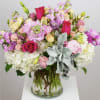 Mixed pink and white flowers arranged in a clear glass vase