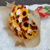 Bouquet of sunflowers and red and white roses wrapped in tan paper