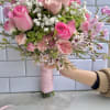 Hand-tied bouquet of pink roses and white baby's breath