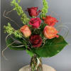 Mixed roses in a clear glass vase with curly greenery