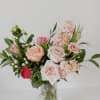 Bouquet of pink and peach roses in a clear glass vase