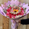 Pink and red rose bouquet with a sunflower center and butterfly decorations
