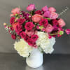 Pink and white floral arrangement in a white vase