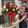 Tall bouquet of red and white roses in a glass vase with a red bow