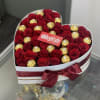 Heart-shaped box of red roses and gold-wrapped chocolates with a satin bow