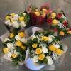 Bouquets of red, yellow, and white roses wrapped in paper