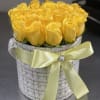 Yellow roses arranged in a round hatbox with a satin ribbon