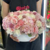 Pink and white rose arrangement in a white hat box with ribbon
