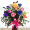 Colorful rose bouquet in a vase with a pink ribbon