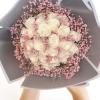 Bouquet of white roses with pink filler flowers in gray wrapping