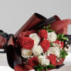 Bouquet of red and white roses wrapped in burgundy and black paper