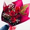 Bouquet of red roses with white baby's breath in burgundy wrap