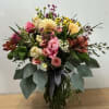 Mixed bouquet of pink and yellow flowers in a glass vase