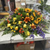 Large mixed floral arrangement with sunflowers, roses, lilies, and purple blooms
