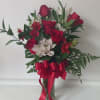 Red roses and white lilies in a glass vase with a red ribbon