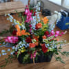 Large mixed floral arrangement with red, pink, orange, and white blooms