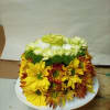 Yellow and white chrysanthemum arrangement on a white plate