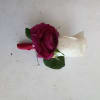 Magenta rose boutonniere with white ribbon and green leaves
