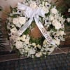 White floral funeral wreath with a satin bow and ribbon